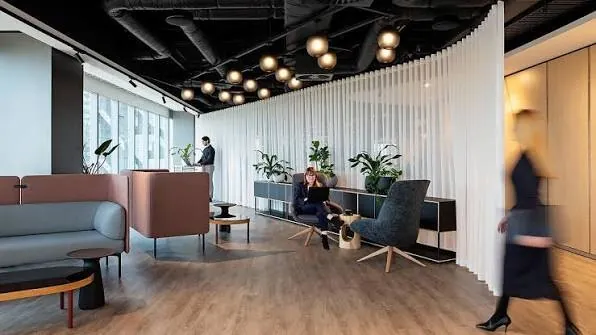 Consultant presenting to a small group in a meeting room, wide